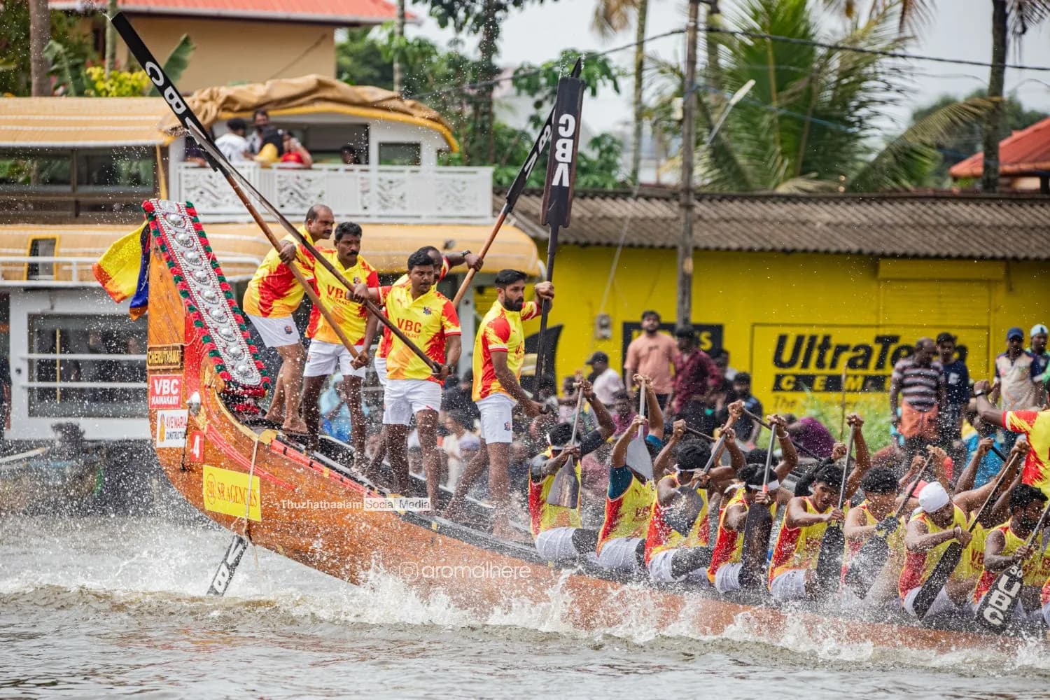 VBC Kainakary steersmen driving their snake boat through the spray