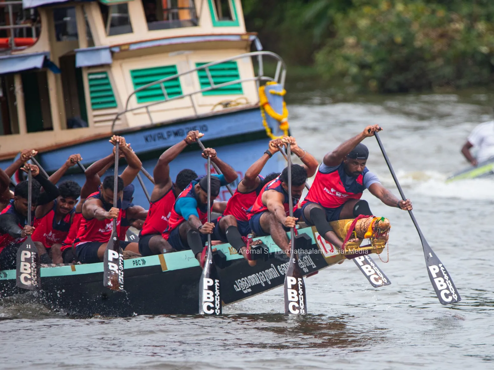 PBC Pallathuruthy paddlers reaching forward at the bow