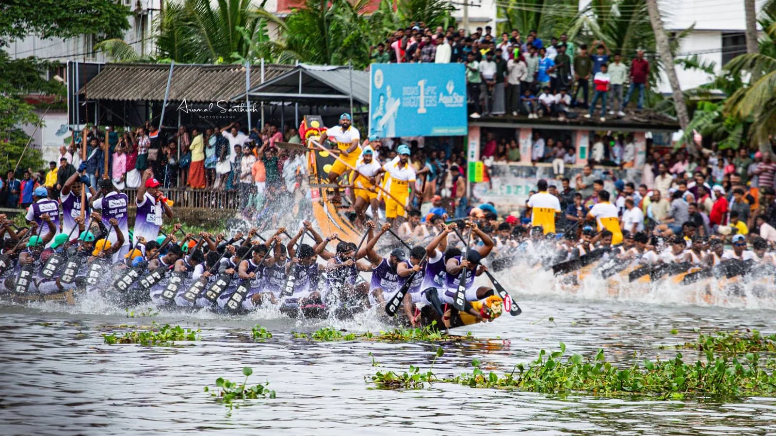 PBC crew and a rival boat racing side by side, water erupting around the paddles